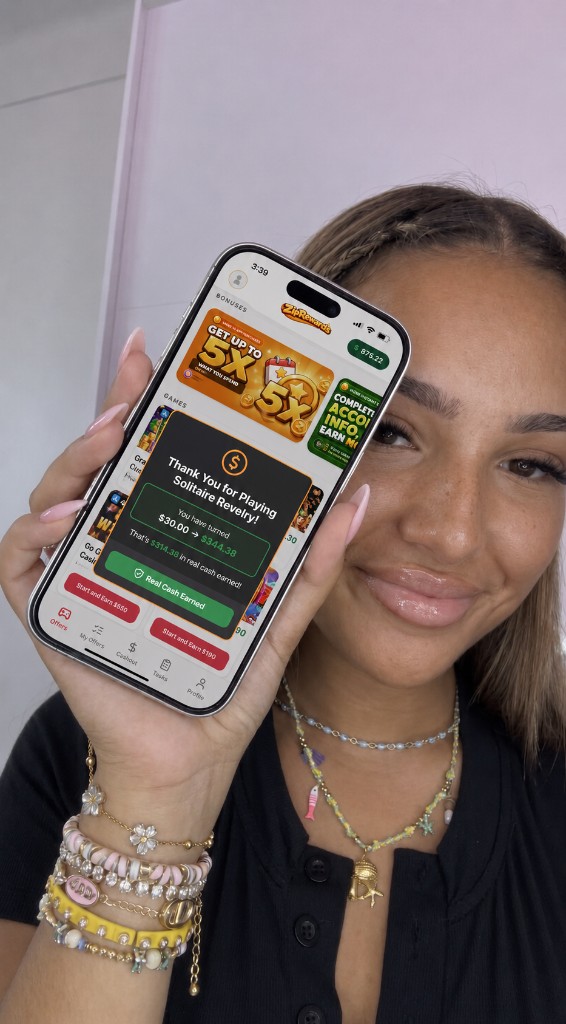 Player holding phone showing cash earned in the rewards app